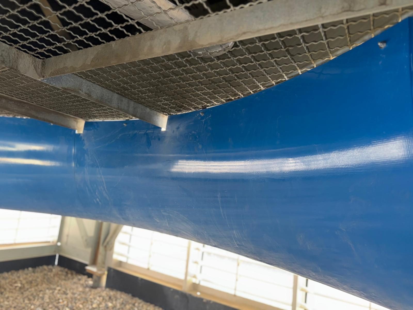 Close view of a fiberglass inlet bell curving up into the fan ring of an air cooled heat exchanger